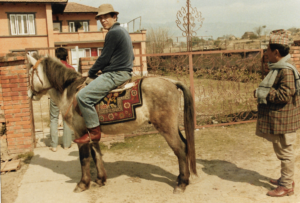 Joe Pietri, the legendary 1960s drug smuggler and cannabis seed collector, riding a horse in a rustic setting, symbolizing his landrace seed expeditions.